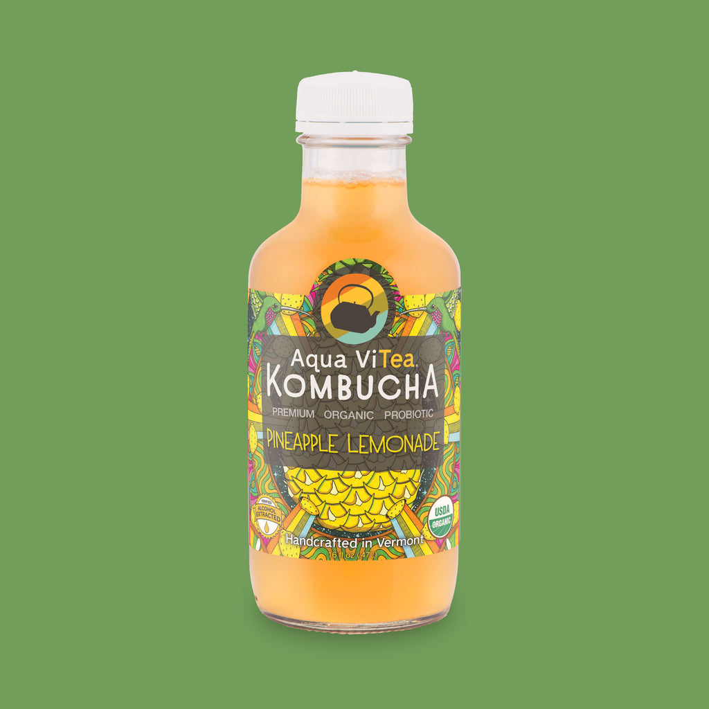 pineapple lemonade kombucha bottle on kelly green background